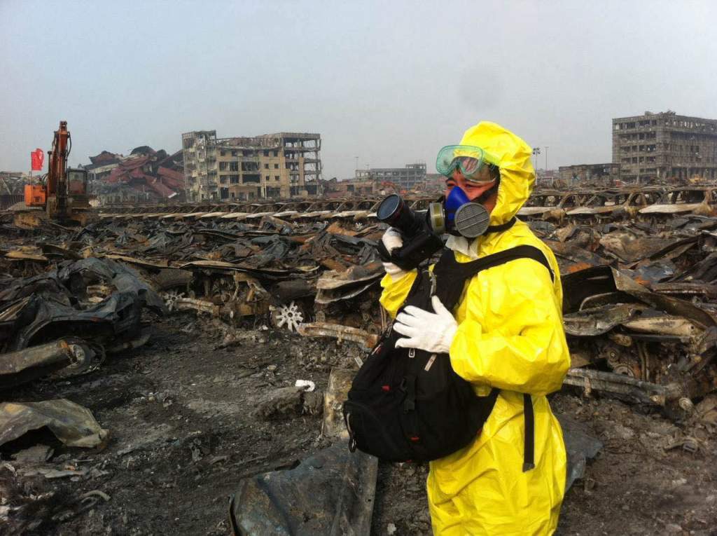 Photo d'un photojournaliste en combinaison de protection sur le site de la double explosion de Tianjin