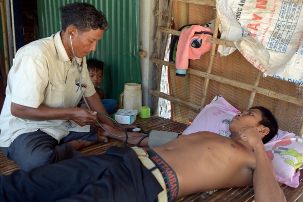 Ken mon, médecin sans licence, prend la tension artérielle d’un patient, dans un village de la province de Kampong Speu au Cambodge. (Crédit : TANG CHHIN SOTHY / AFP)
