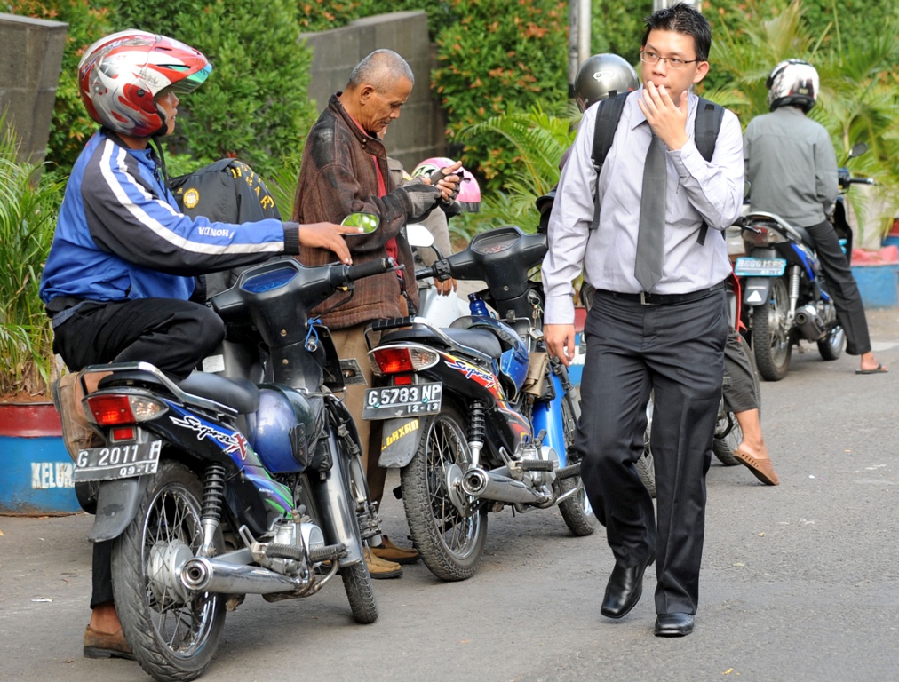 Un employé de bureau cherche un “ojek” ou moto taxi à Jakarta, le 18 août 2011. (Crédit : ADEK BERRY / AFP)