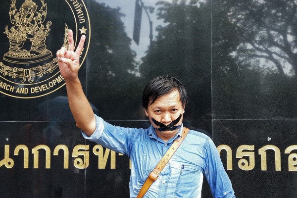 Le journaliste thaïlandais Pravit Rojanaphruk devant une base militaire à Bangkok où il a été convoqué le 25 mai 2014. Plus récemment, le 14 septembre 2015, un autre journaliste thaï a été arrêté par la junte pour subir un “réajustement d’attitude”. (STR / AFP PHOTO)