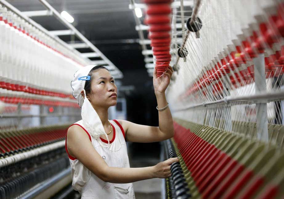 Une ouvrière chinoise sur une ligne de production de fil de laine pour l’exportation ans les pays d’Asie du Sud-Est, dan sune usine textile de Huabei dans la province chinoise côtière de l’Anhui, le 28 août 2015. (Crédit : Xie zhengyi / Imaginechina / via AFP)