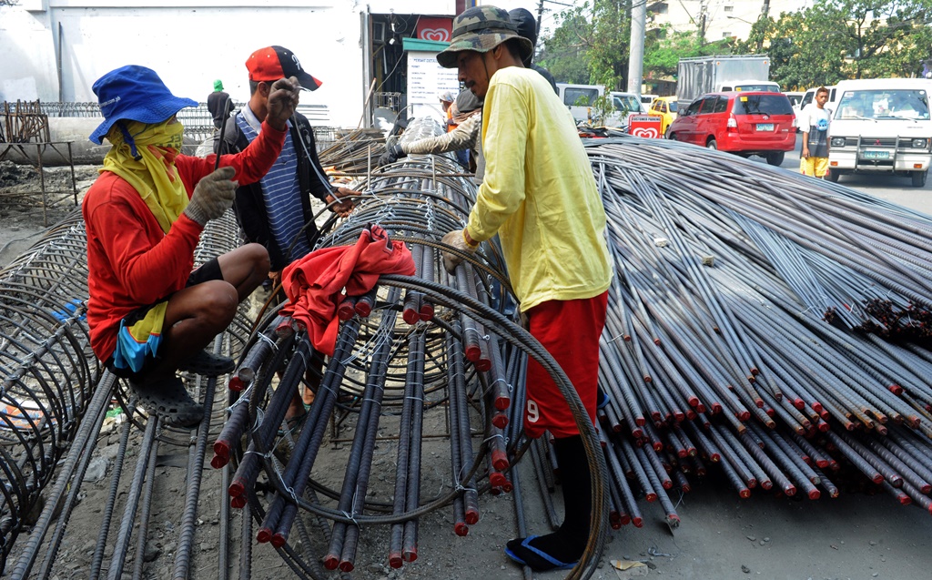 Ouvriers philippins sur kle chatier d'un nouvel immeuble à Manille le 17 janvier 2014.