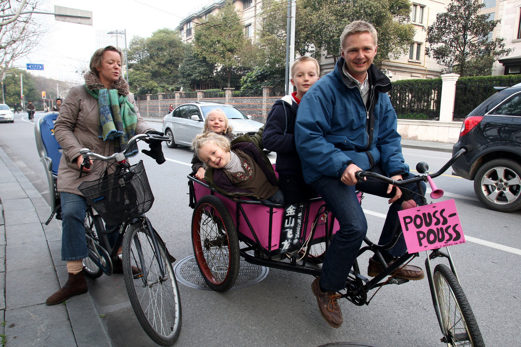 Un français, Loïc Delcroix, responsable financier chez Dongfeng Citröen, et sa famille sur un tricycle chinois typique dans les rues de Shanghaï.