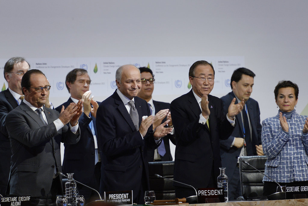 François Hollande, le président français ; Laurent Fabius, le ministre des affaires étrangères français ; Ban Ki-moon, le secrétaire général des nations Unies et Christiana Figueres, secrétaire exécutive de la Convention-cadre des Nations unies sur les changements climatiques (CCNUCC) applaudissent après qu’un accord ait été trouvé à la COP21.