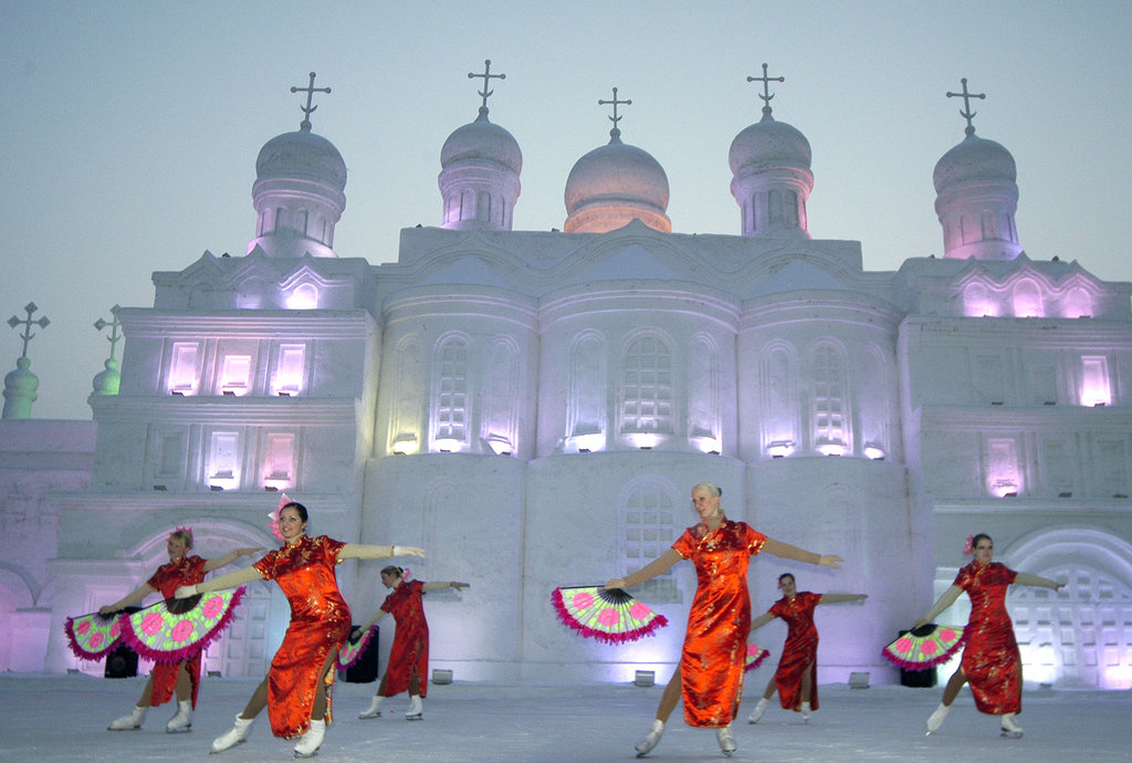 Des danseurs russes exécutent des danses traditionnelles devant l’une des gigantesques sculptures de glace du festival d’Harbin.