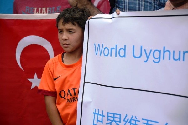 Un enfant ouïghour tient une banderole lors d'un rassemblement devant l'ambassade de Thaïlande à Ankara le 9 juillet 2015, pour protester contre le renvoi de 115 Ouïghours ayant migré à Bangkok vers la Chine contre leur volonté