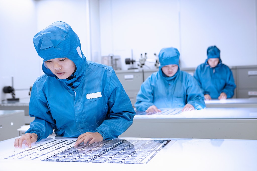 Ouvrières chinoises en "salle propre" d'une usine d'appareils électroniques flexibles.