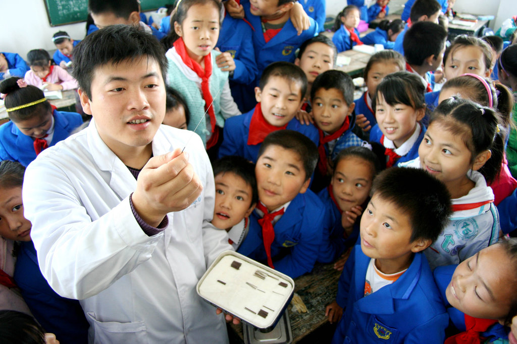 Un professeur présente à ses élèves de primaire des aiguilles d’acupuncture durant une classe de présentation de la médecine chinoise.