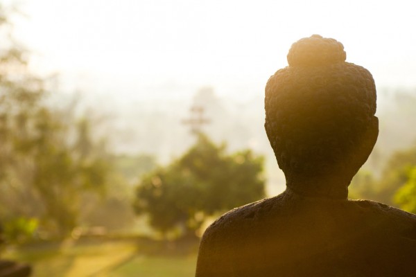 Une statue de Bouddha en pierre dans le soleil du matin.
