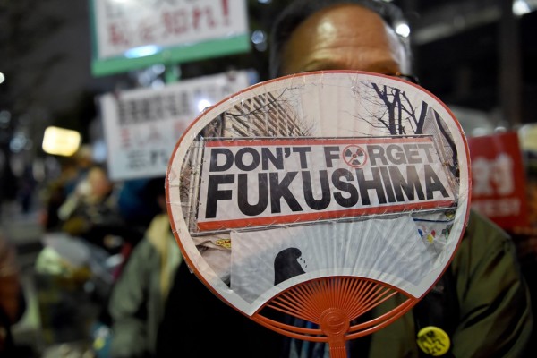 Un manifestant japonais tient un éventail anti-nucléaire lors d'un rassemblement devant le parlement à Tokyo le 11 mars 2016.