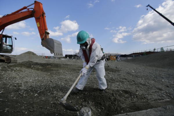 Un ouvrier portant une combinaison protectrice terrasse la terre dans l’enceinte de la centrale gérée par Tokyo Electric Power Co's dans la préfecture de Fukushima