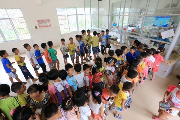 Des enfants d'une école de Liuzhou dans la province chinoise du Guangxi font la queue pour recevoir leur déjeuner.