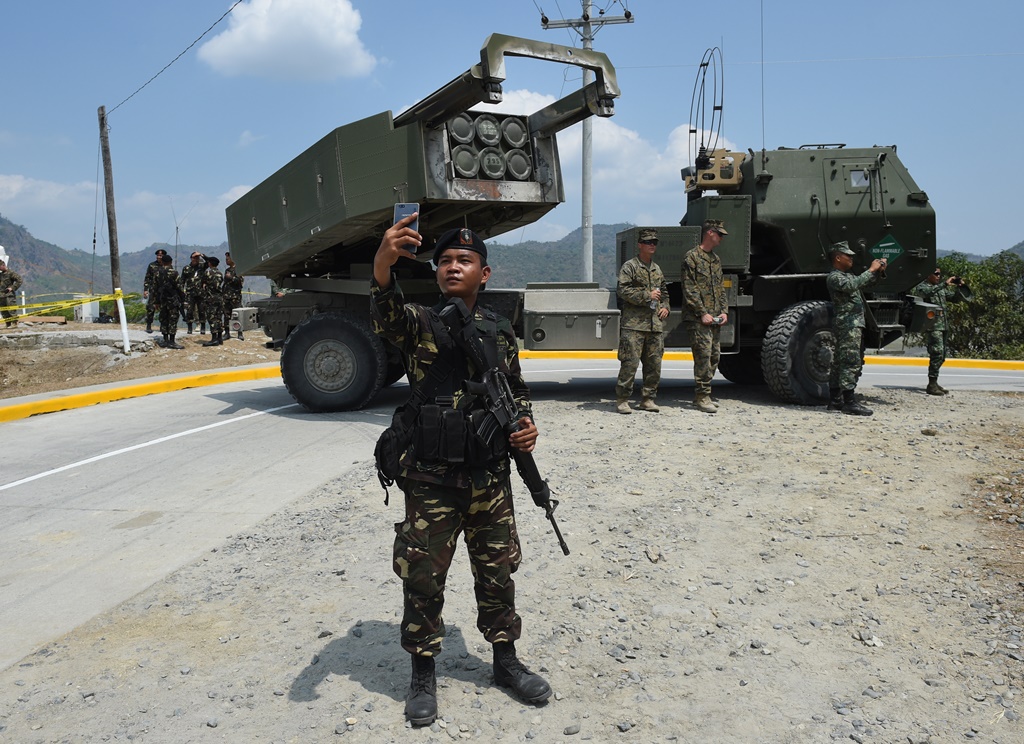 Un soldat philippin prend un selfie devant le système de missile américain M142 High Mobility Artillery Rocket System (HIMARS)