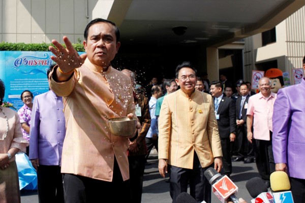 Le Premier ministre thaïlandais Prayuth Chan-ocha jette de l'eau sur un groupe de journalistes devant le bâtiment du gouvernement avant le conseil des ministres le 5 avril 2016 à Bangkok.