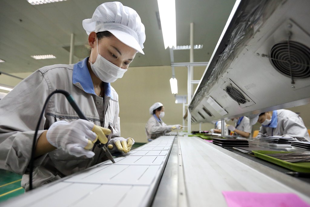 Une ouvrière chinoise travaille sur des cellules photovoltaïques pour panneaux solaires destinés à l'exportation vers l'Europe et les Etats-Unis, à l'usine de Shanghai Shenzhou New Energy Development Co., Ltd, dans la ville de Lianyungang, dans la province chinoise du Jiangsu, le 21 mai 2014.