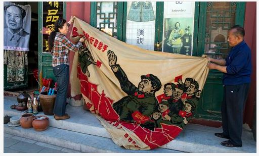 Des vendeurs dans un marché de curiosités à Pékin déploient une banderole représentant Mao Zedong "inspectant la grande armée de la Révolution culturelle". Copie d'écran du "Global Times", le 17 mai 2016