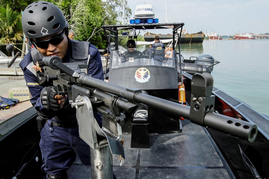 Un membre de la Malaysian Maritime Enforcement agency dans un bateau de défense à coque rigide fabriqué au Canada, après une cérémonie de passage témoin à Malacca, à 148 km de Kuala Lumpur le 18 juin 2014.