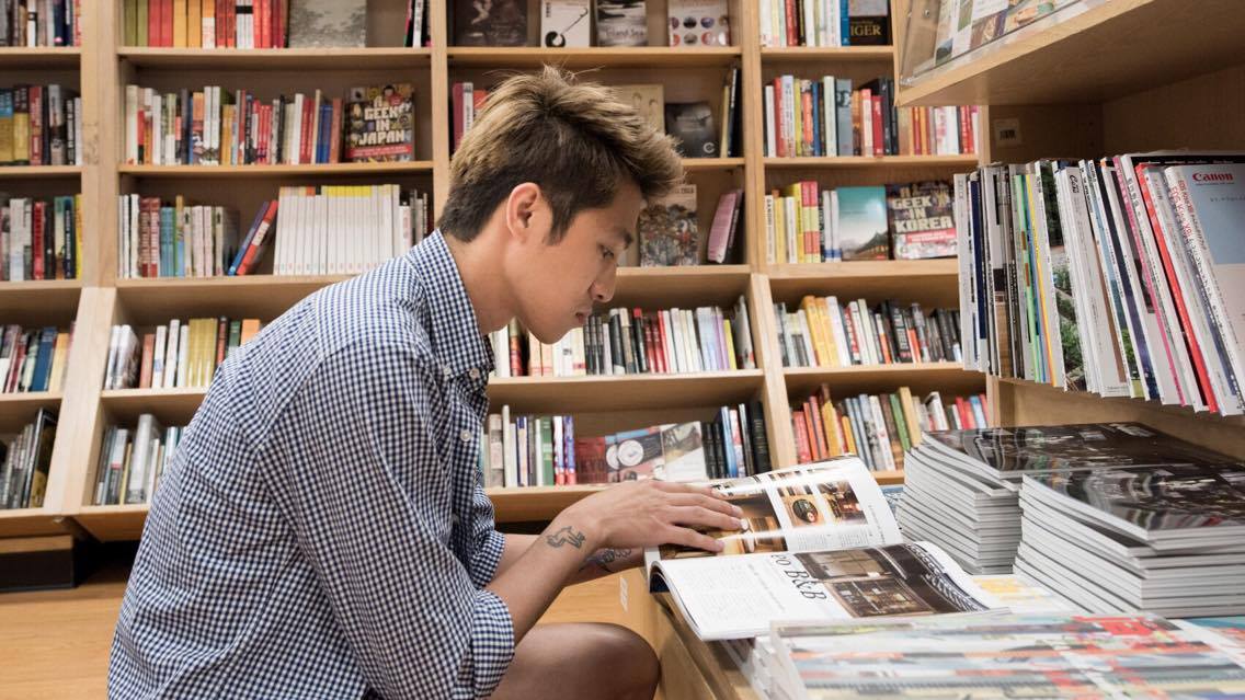 Jeune taïwanais en train de lire dans une bibliothèque