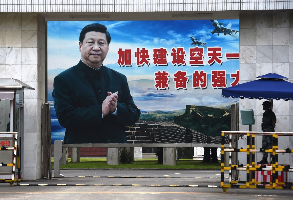 Sur un panneau géant à Guilin, dans la province chinoise méridionale du Guangxi le 13 mai 2016, le président chinois Xi Jinping applaudit le slogan suivant : "Accélérer le renforcement d'une armée de l'air puissante et aguerrir les capacités d'attaque et de défense".