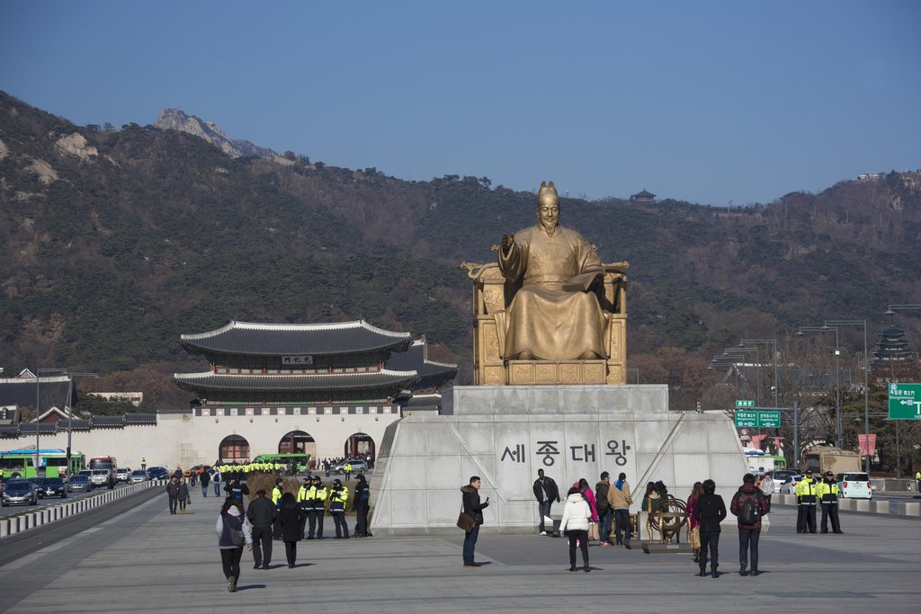 Le roi Sejong, souverain humaniste et inventeur de l'alphabet coréen, a donné son nom à une avenue de la capitale sud-coréenne. Ici, sa statue sur Sejong-daero, à Séoul, avec en arrière-plan le palais Gyeongbok, le palais du Bonheur resplendissant.
