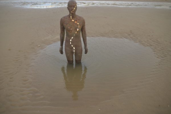 Une statue en fer de l'artiste Antony Gormley installée sur la plage de Crosby Beach en Angleterre.