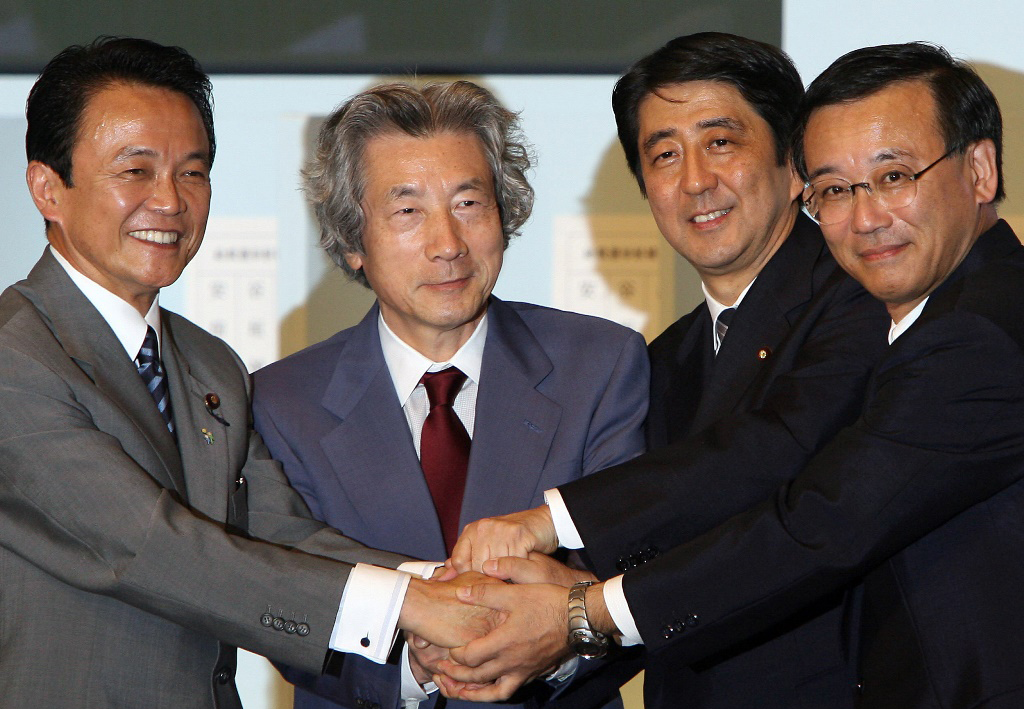 Shinzo Abe le jour de son élection à la tête du Parti libéral-démocrate (PLD), le 20 septembre 2006 à Tokyo, avec les autres candidats au poste, le ministre des Finances Sadakazu Tanigaki (à droite), le ministre des Affaires étrangères Taro Aso (à gauche) et le Premier ministre sortant Junichiro Koizumi (2ème à gauche).