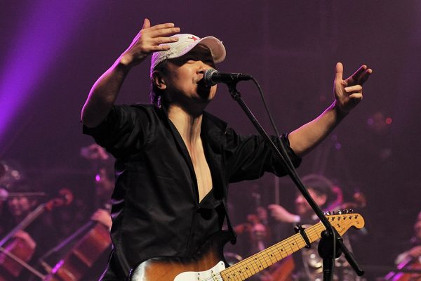 Le guitariste-chanteur Cui Jian, surnommé le "parrain du rock chinois", avec le chef d'orchestre Tan Lihua et l'orchestre philarmonique de Pékin lors du "Rock Symphony New Year's concert" le 31 décembre 2010 au Gymnase des Travailleurs de Pékin.