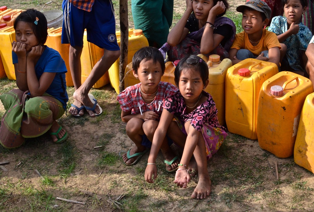 En Birmanie, Des enfants des deux communautés religieuses musulmane et bouddhitse attendent de pouvoir puiser l’eau dans un village du Rakhine.