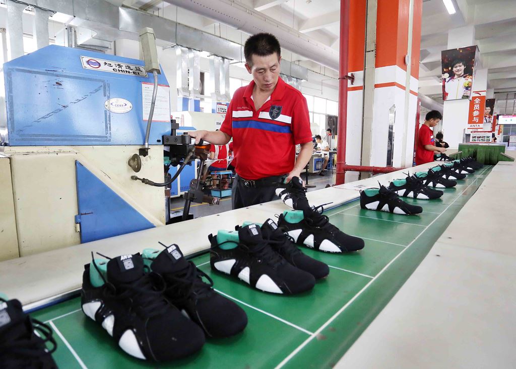 Un ouvrier chinois examine des chaussures de sport dans une manufacture de Jinjiang, dans la province du Fujian au sud-est de la Chine, le 27 juillet 2016.