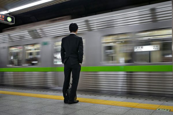 Un "salaryman" sur le quai d'une gare de Tokyo.