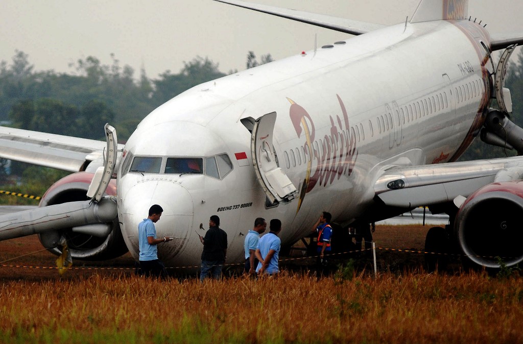 En Indonésie, des responsables entourent le boeing 737 de la Batik Air après que l'avion a dérapé hors de la piste à l'atterrissage à l'aéroport de Yogyakarta le 6 novembre 2015, pour un bilan de 167 blessés dont 7 membres de l'équipage. (Crédits : Juli Nugroho / NurPhoto / via AFP)