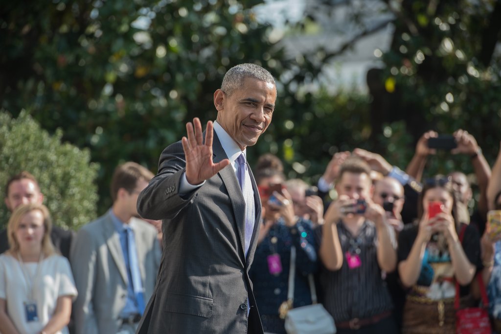 Le président américain Barack Obama salue la foule lors de son départ de la Maison Blanche pour Miami, le 20 octobre 2016.