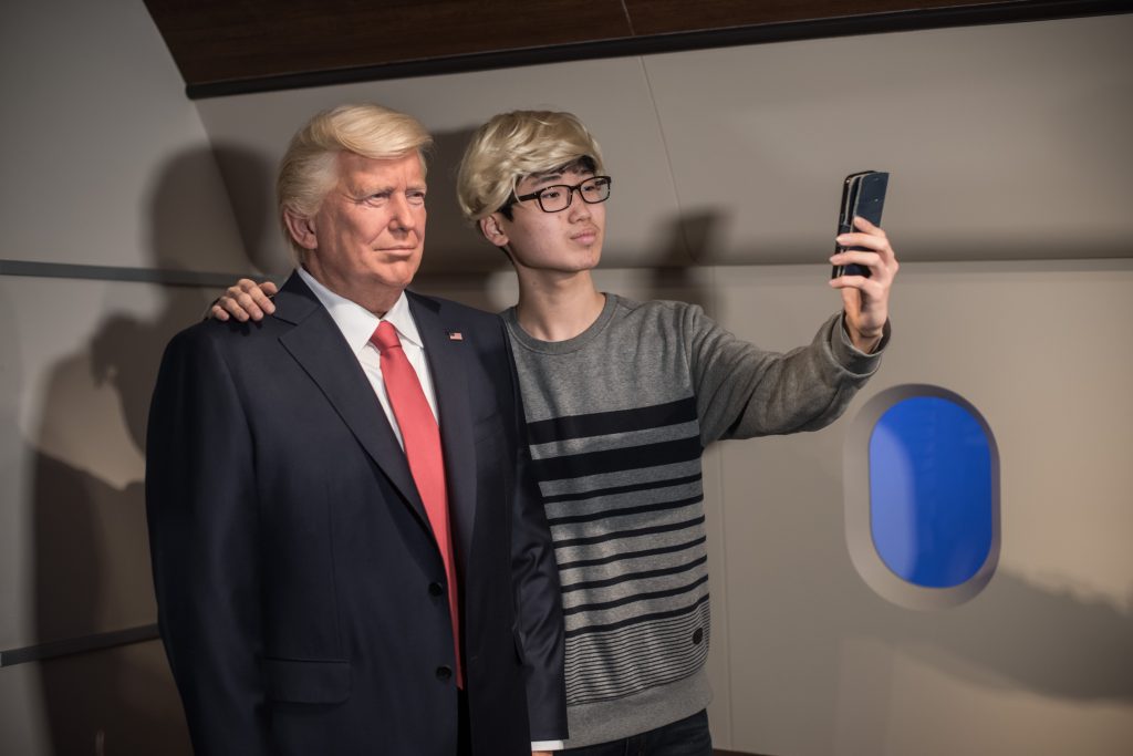 Un visiteur se prend en photo devant le mannequin de cire de Donald Trump au musée Grévin de Séoul, le 20 janvier 2017. (Crédits : Ed JONES / AFP)