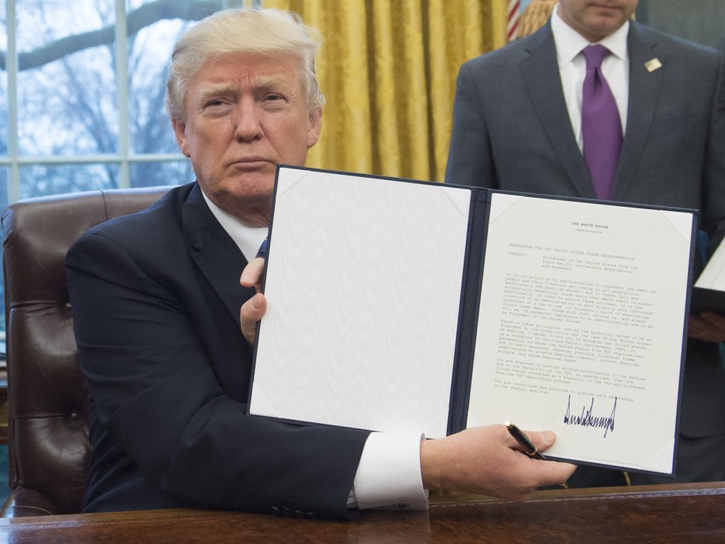 Le président américain Donald Trump présente le décret qu'il vient de signer pour retirer les Etats-Unis du Partenariat transpacifique, dans le bureau oval de la Maison-Blanche à Washington, le 23 janvier 2017. (Crédits : AFP PHOTO / SAUL LOEB)