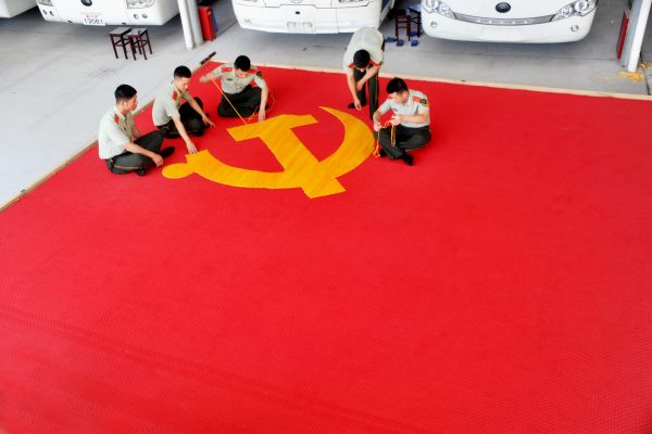 A la veille des célébrations des 95 ans du Parti Communiste Chinois le 30 juin 2016, des membres du Parti cousent un drapeau.