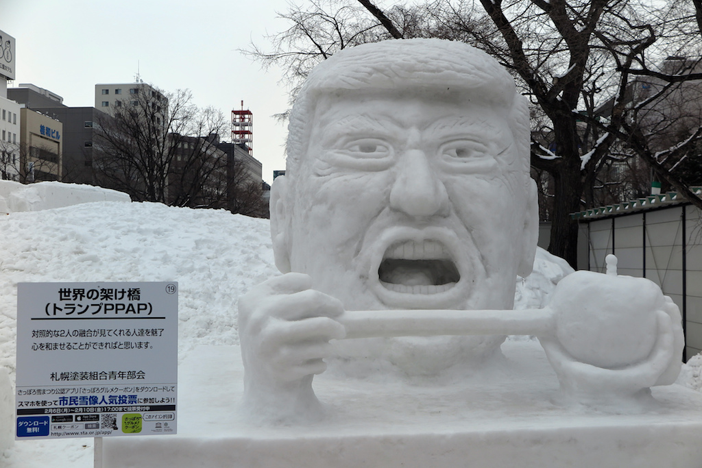 Un buste géant du président Donald Trump tout en neige, s'apprêtant à mordre dans un stylo planté dans un ananas, au festival de la neige à Sapporo, le 6 février 2017. (Crédits : Lars Nicolaysen/dpa/via AFP)