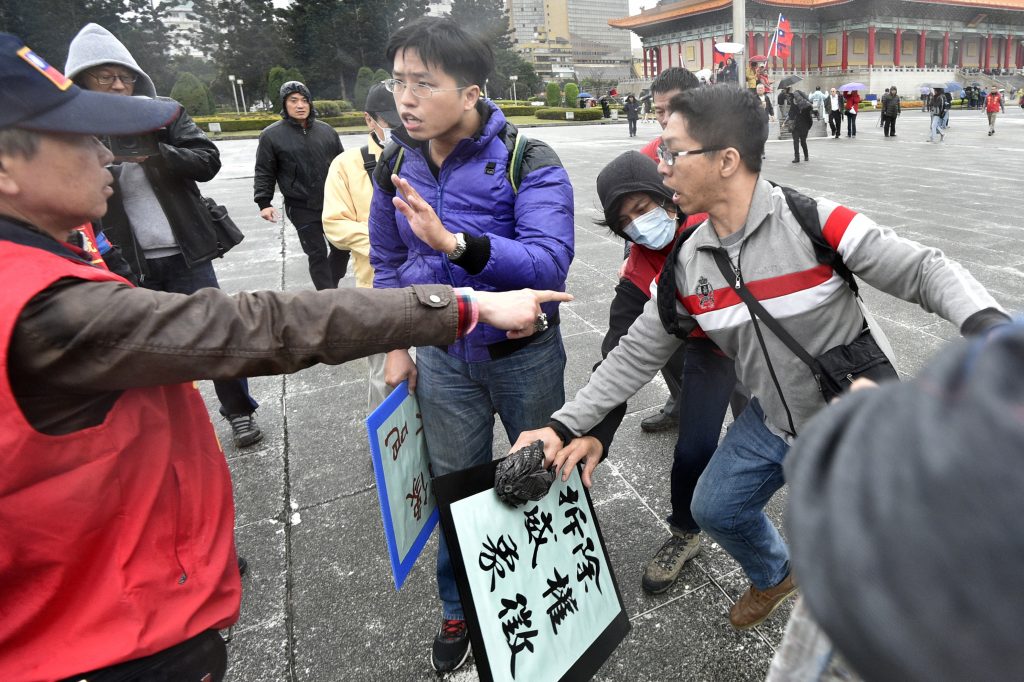 Un militant pro-unification avec la Chine s'oppose à deux activistes pro-indépendance lors des commémorations du 70ème anniversaire de la répression du 27 février 1947, devant le mémorial Chiang Kai-shek à Taipei, le 28 février 2017. (Crédits : AFP PHOTO / Sam YEH)