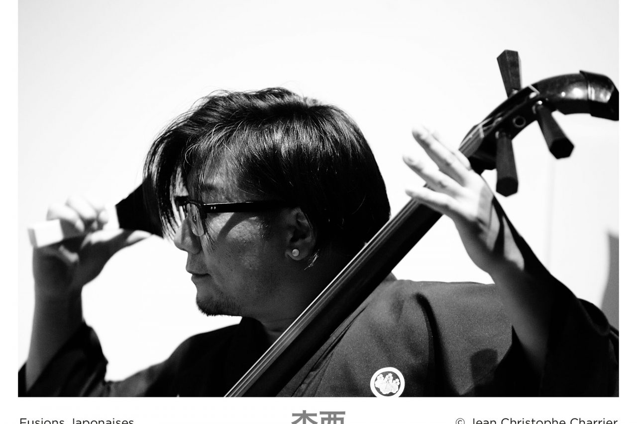 Hideaki Tsuji jouant du shamisen lors d'un concert fusions japonaises à la salle du Senechal durant le festival Made in Asia. (Copyright : Jean Christophe Charrier)
