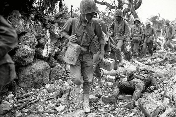 Photo prise en avril 1945 : des marines américains traversent un village à Okinawa, Japan, où des soldats nippons gisent sur le bord du chemin après la sanglante bataille sur l'île. (Crédits : AFP PHOTO/THE NATIONAL ARCHIVES/NORRIS G. MCELROY)
