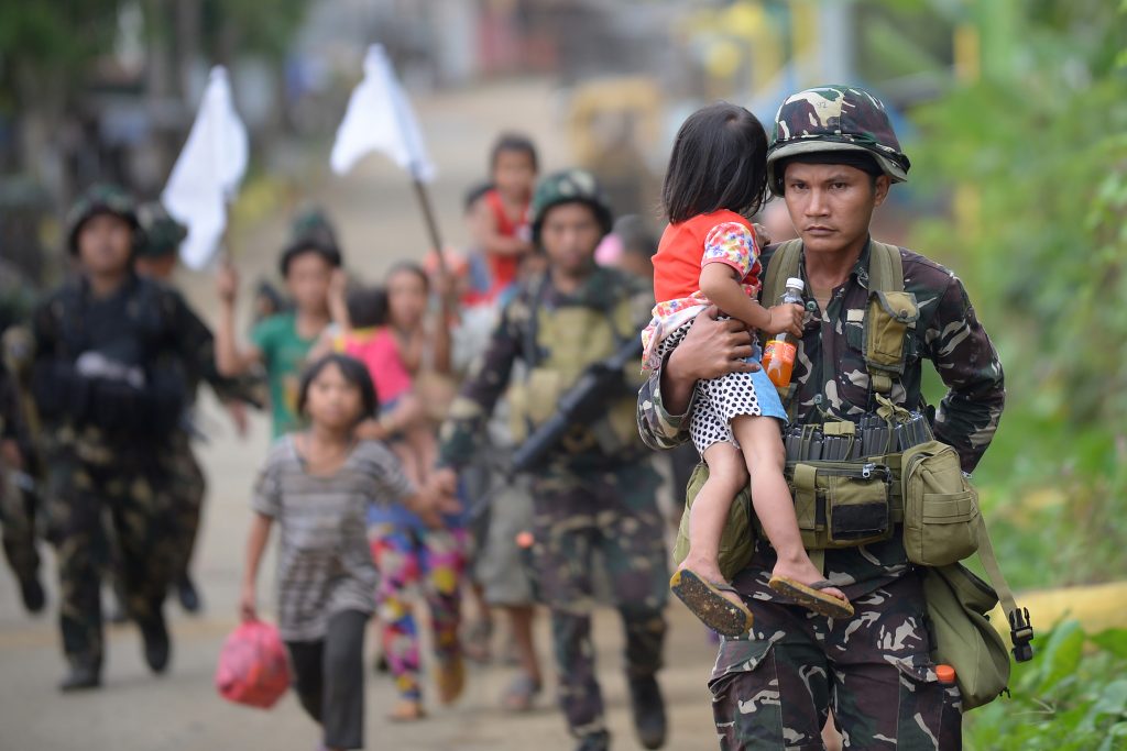 Des soldats philippins escortent les civils d'un village proche de Marawi dans l'île de Mindanao au sud des Philippines, le 31 mai 2017. (Crédits : AFP PHOTO / TED ALJIBE)