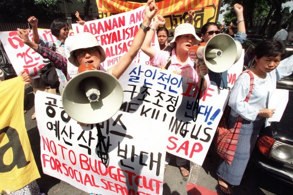 Des représentantes d'agricultrices venues du Laos, d'Indonésie, du Vietnam, de Malaisie, de Corée du Sud, du Japon et de Thaïlande manifestent contre le Fonds Monétaire International (FMI) et la Banque Mondiale devant le siège de la Bank of Thailand à Bangkok le 13 août 1999. (Crédits : AFP PHOTO/Pornchai KITTIWONGSAKUL)