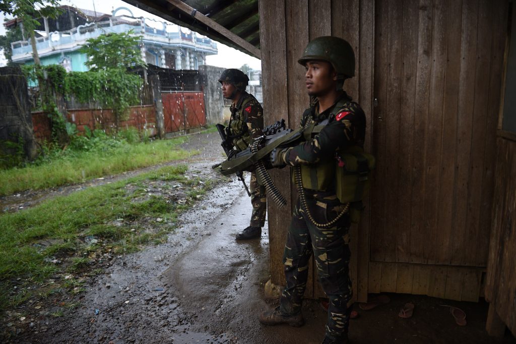 Des soldats gouvernementaux prennent position contre des snipers du groupe Maute, alors qu'ils escortent des résidents hors de Marawi au sud des Philippines, le 1er juin 2017. (Crédits : AFP PHOTO / TED ALJIBE)