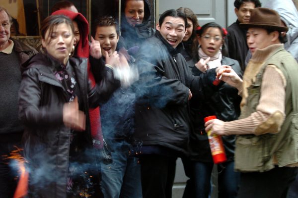 Des jeunes chinois lancent des pétards dans le quartier chinois, le 24 janvier 2004 dans le IIIe arrondissement de Lyon, à l'occasion du Nouvel-An chinois.