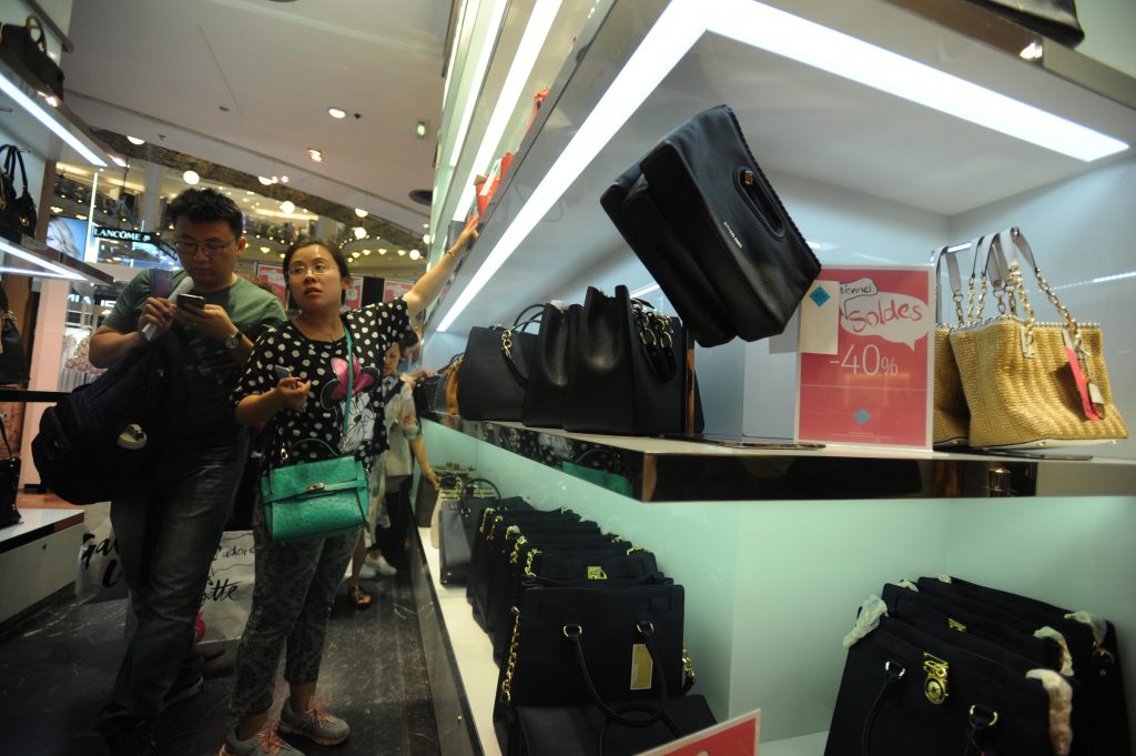 Des clients chinois font leur shopping aux galeries Lafayette durant les soldes estivales à Paris, le 1er juillet 2016. (Crédits : Cui jingyin / Imaginechina / via AFP)