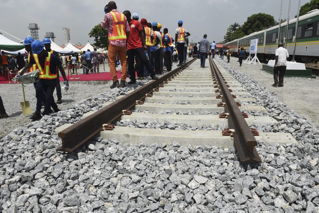 Des ouvriers nigérian le long d'un prototype de ligne de chemin de fer, qui sera construite par la China Railway Construction Corporation (CRCC), lors de la cérémonie de lancement du chantier de la ligne Lagos-Ibadan près du siège de la Nigerian Railway Corporation à Lagos, le 7 mars 2017. (Crédits : AFP PHOTO / PIUS UTOMI EKPEI)