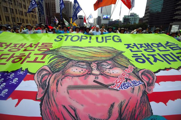 Des manifestants sud-coréens arborent une banderole avec une caricature du président américain Donald Trump lors d'une marche pour la paix dans la péninsule coréenne, près de l'ambassade américaine à Séoul le 15 août 2017. (Crédits : AFP PHOTO / JUNG Yeon-Je)