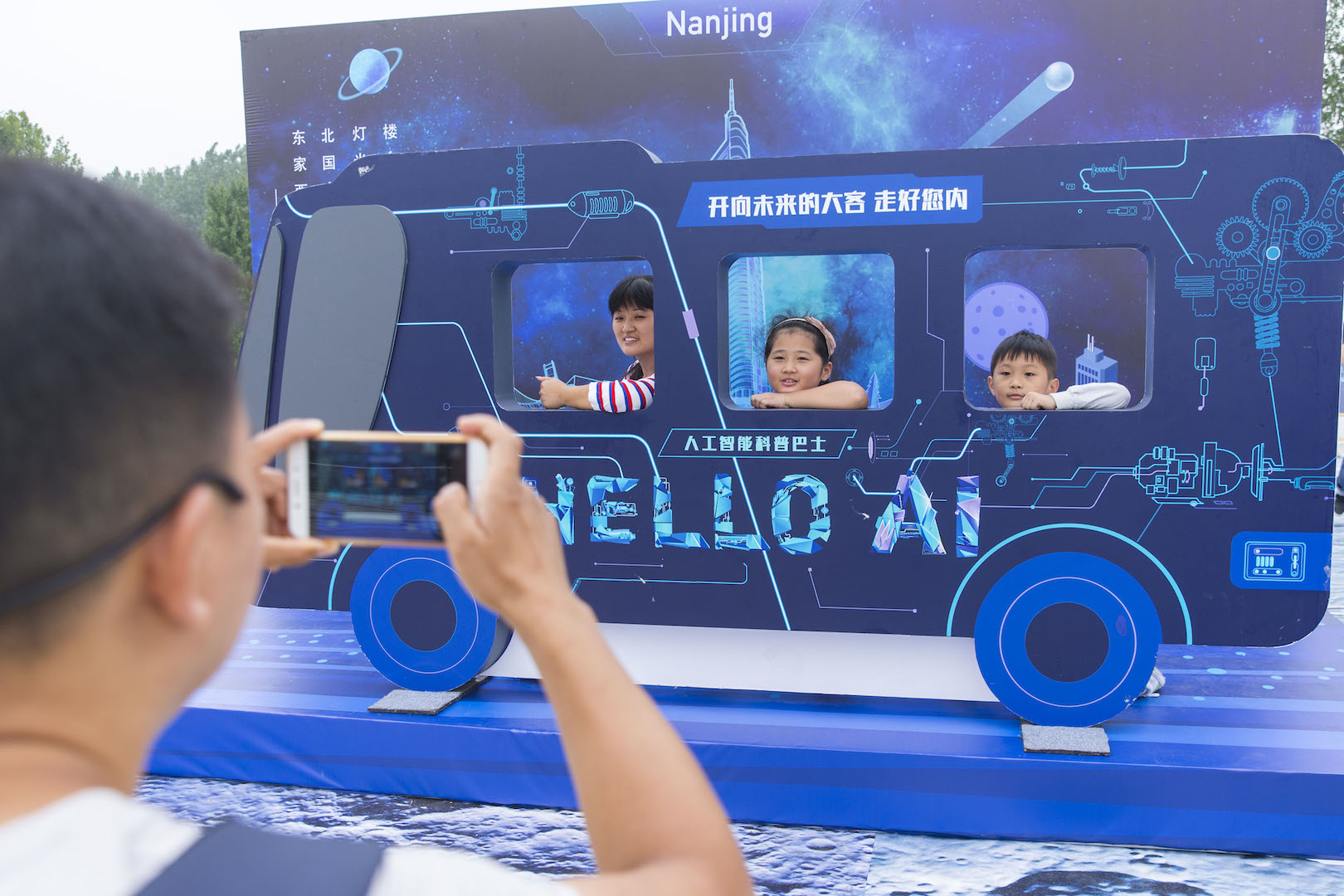 "Hello AI !", "Salut l'intelligence artificielle !" Des visiteurs chinois expérimentent l'intelligence artificielle dans le Baidu AI Bus lors d'une exposition de vulgarisation scientifique organisée par le géant chinois des moteurs de recherche à Nankin, dans la province chinoise du Jiangsu, le 8 septembre 2017. (Crédits : CHENG JIABEI / IMAGINECHINA / via AFP)