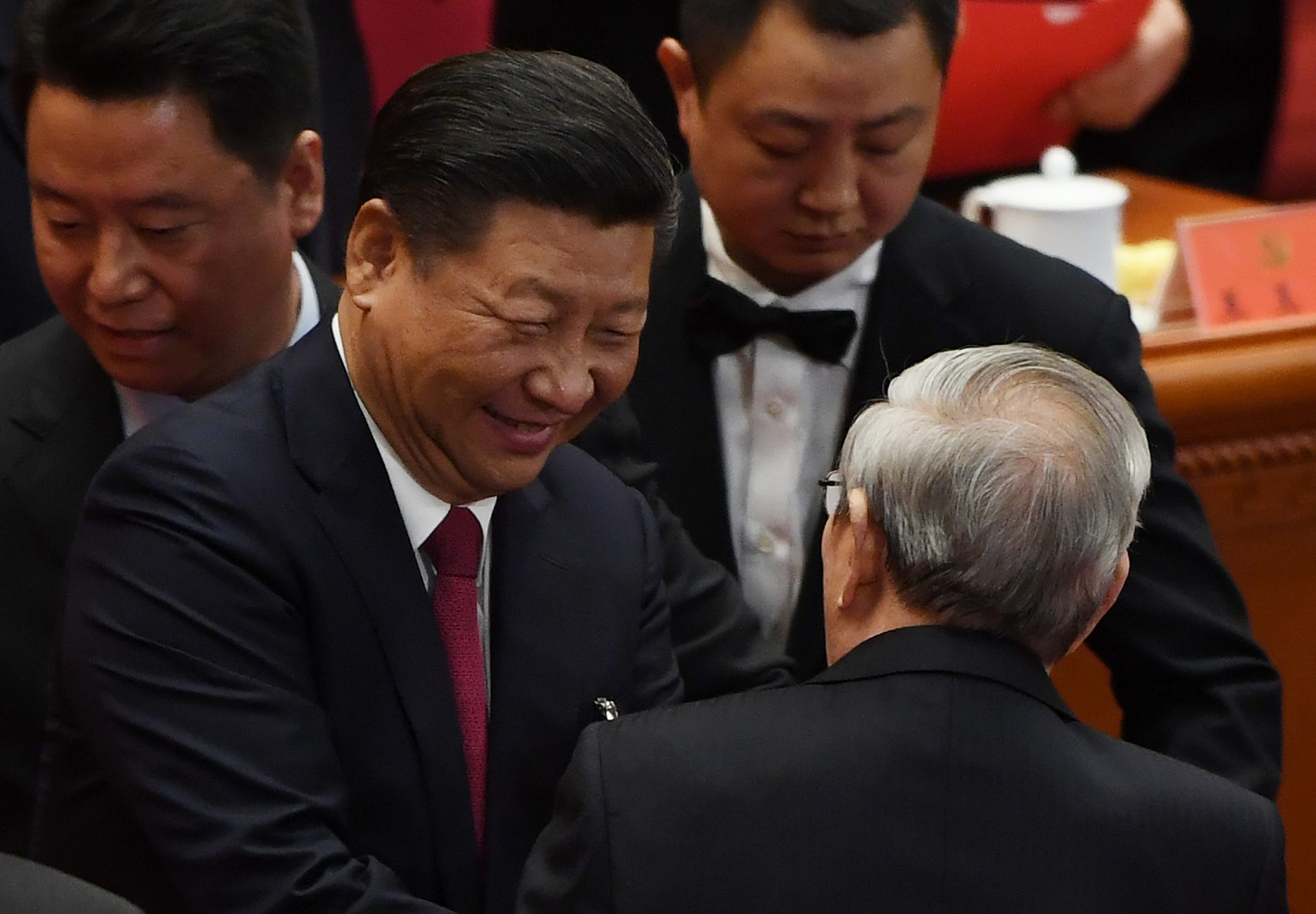 Le président chinois Xi Jinping salue l'ancien Premier ministre Zhu Rongji lors de la clôture du 19ème Congrès du Parti communiste chinois dans le Grand Hall du Peuple à Pékin, le 24 octobre 2017. Le secrétaire général du Parti a obtenu sans surprise un nouveau mandat de 5 ans et l'inscription de sa "pensée" avec son nom dans la Charte du Parti, faisant de lui l'égal de Mao et deng au panthéon communiste chinois. (Crédits : AFP PHOTO / GREG BAKER)