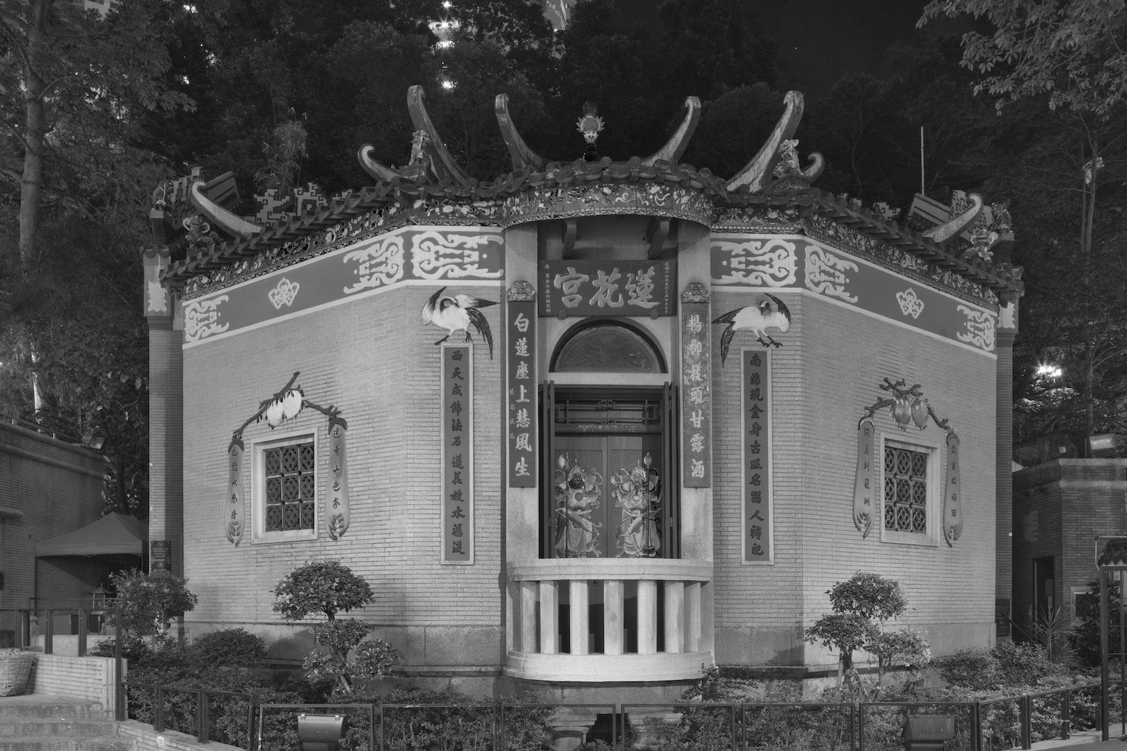 Extrait de la série "Temples" par Dick Chan : la nuit, les images des deux dieux du temple apparaisse plus clairement sur la porte. Hong Kong, 2017. (Copyright : Dick Chan)