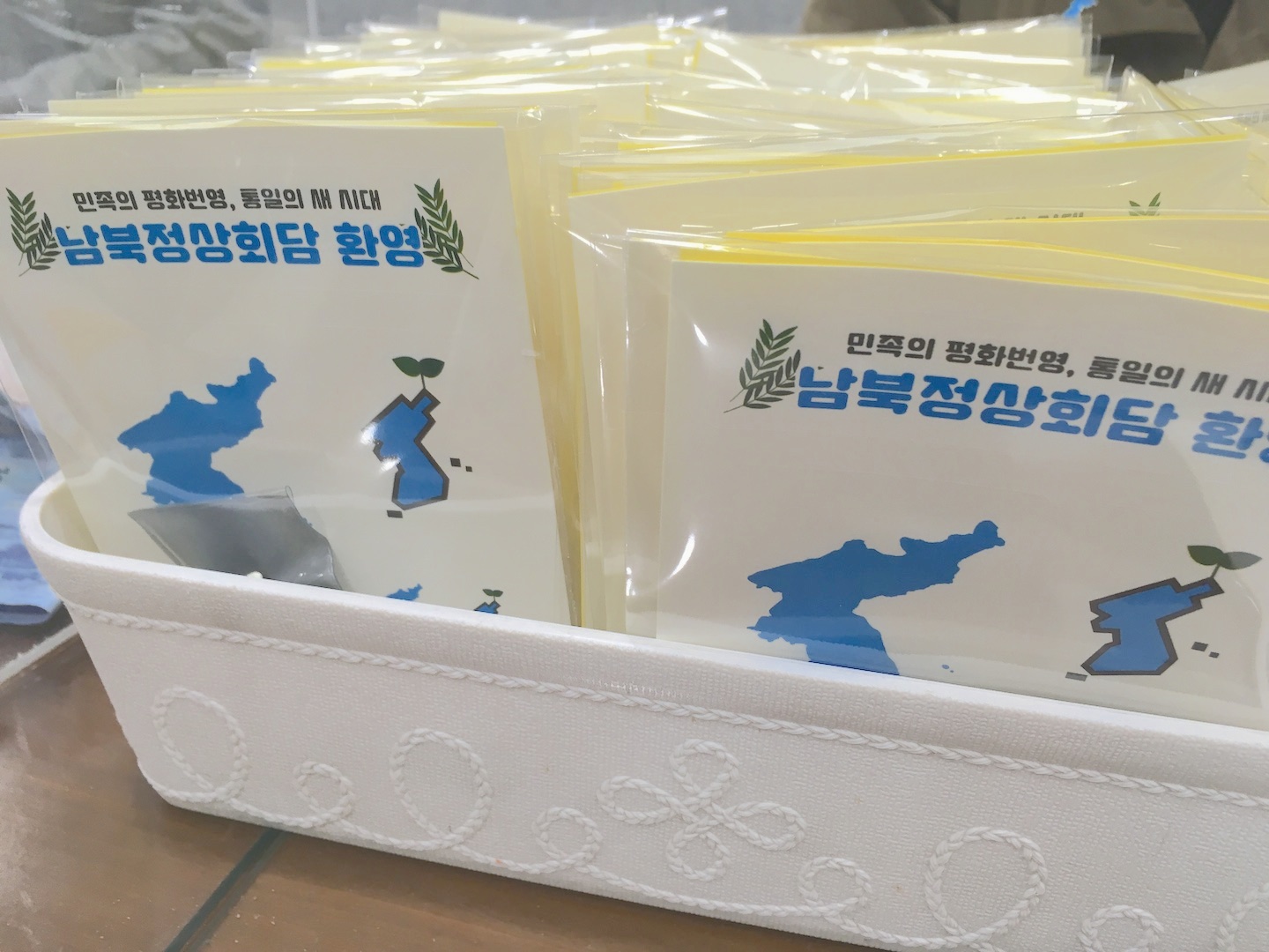 Distribution de cartes et pin's de la paix montrant une péninsule bleue sur fond blanc à Pusan en Corée du Sud fin novembre 2018. (Crédits : Asialyst / Stéphane Lagarde)